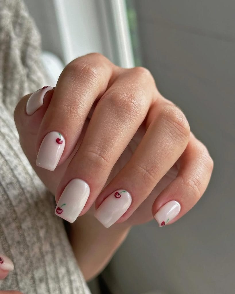 White milky nails with tiny red cherries
