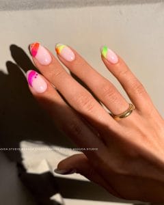 oval July nails with milky base and colorful neon paint splash accents in different bright colors