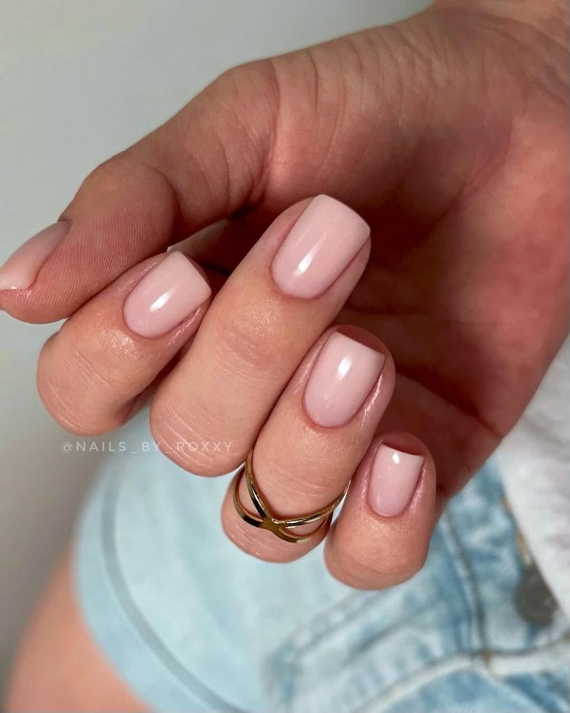 Glossy nude pink neutral nails on short square shape with high shine finish