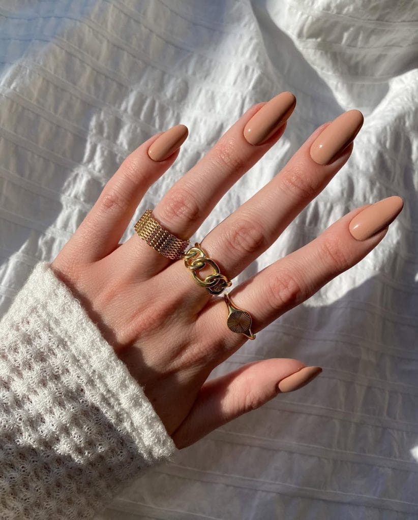 Warm camel brown neutral nails on oval shape with glossy finish